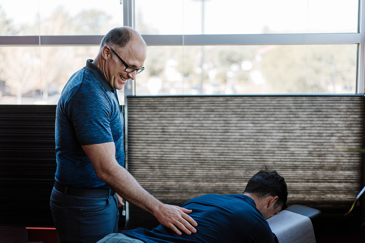 mid back pain chiropractor Dr. Evans adjusting the spine of a young male patient