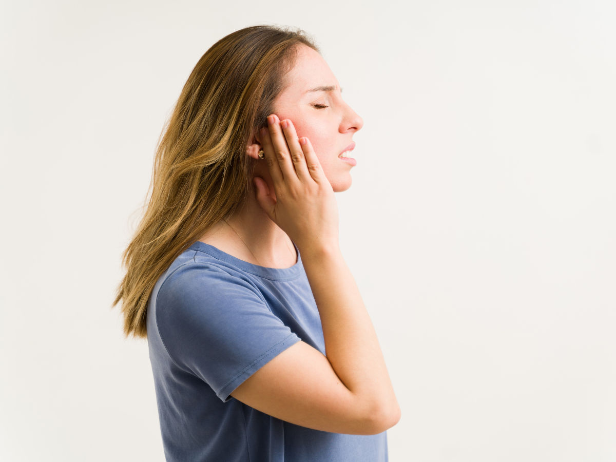 woman holding her ears suffering from tinnitus